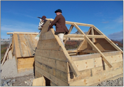 Replica board hut under construction. Note the post and beam construction and the opening for the fireplace. Log huts did not have any frame but did have similar fireplaces. (Fort Ticonderoga)